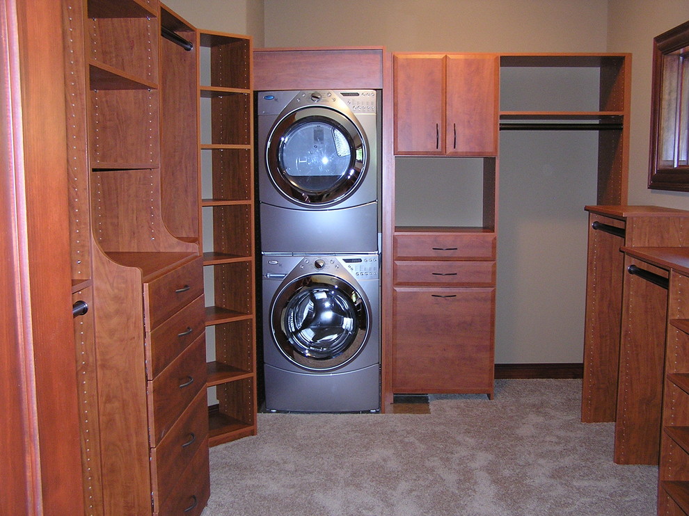 Large traditional gender-neutral walk-in wardrobe in Other with flat-panel cabinets, medium wood cabinets and carpet.
