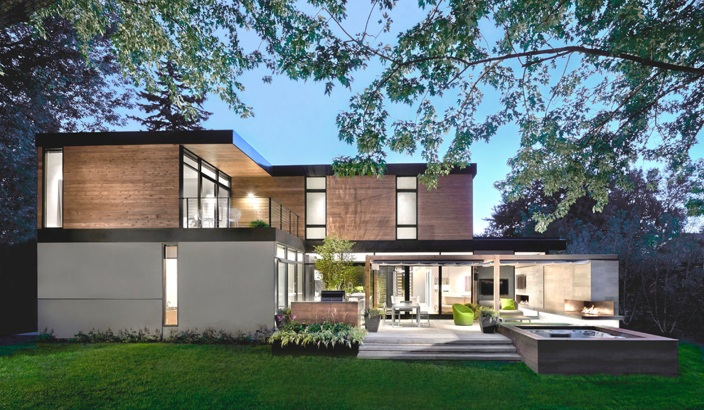 This is an example of a large contemporary two-storey exterior in Chicago with mixed siding and a flat roof.