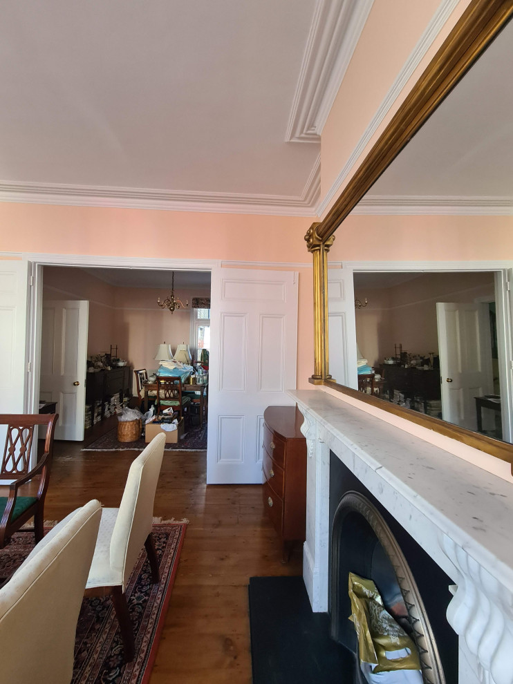 Свежая идея для дизайна: большая гостиная-столовая в классическом стиле с оранжевыми стенами, темным паркетным полом, стандартным камином, фасадом камина из металла, коричневым полом и многоуровневым потолком - отличное фото интерьера