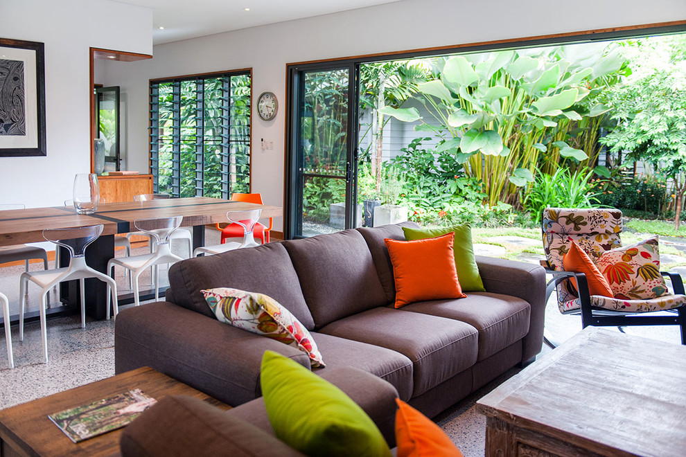 Mid-sized tropical open concept living room in Brisbane with white walls and concrete floors.