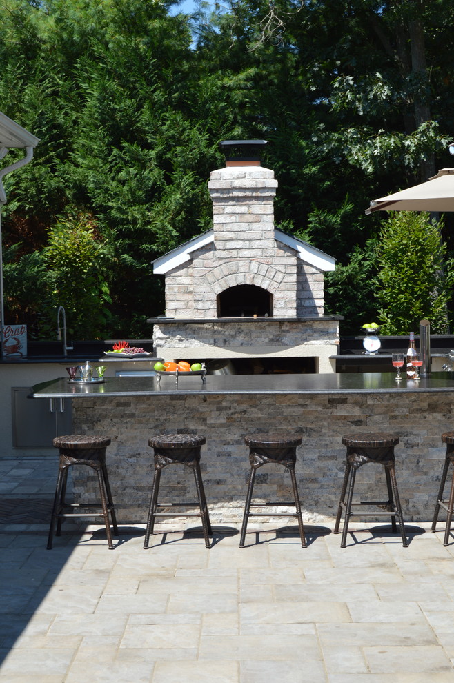 Design ideas for a traditional backyard patio in New York with an outdoor kitchen and concrete pavers.