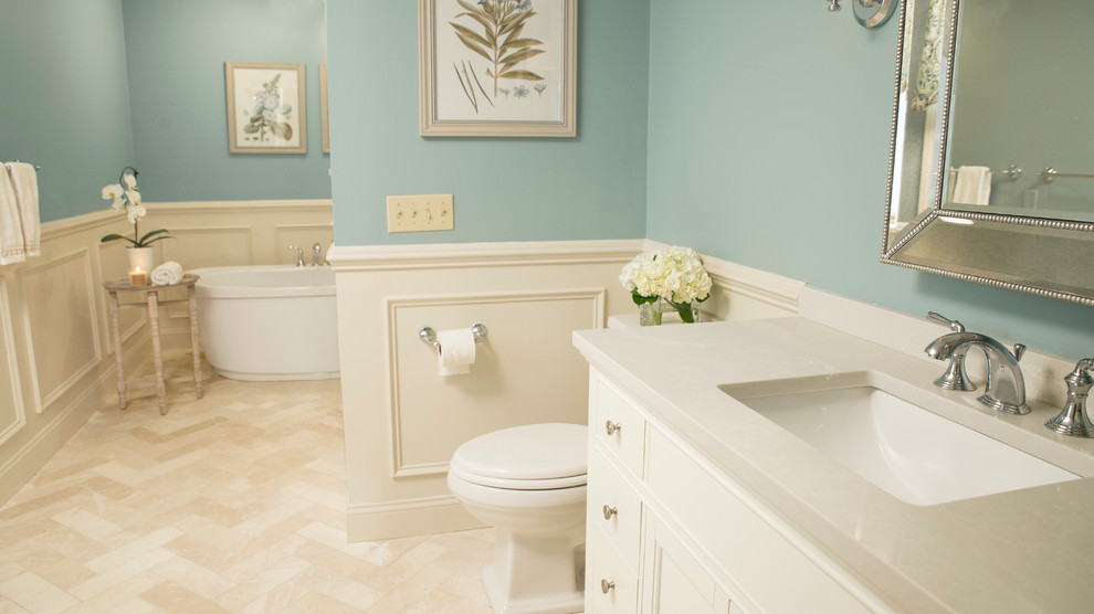 Inspiration for a mid-sized transitional master bathroom in Boston with beige cabinets, a freestanding tub, an open shower, a one-piece toilet, beige tile, ceramic tile, blue walls, ceramic floors, an undermount sink, engineered quartz benchtops and recessed-panel cabinets.