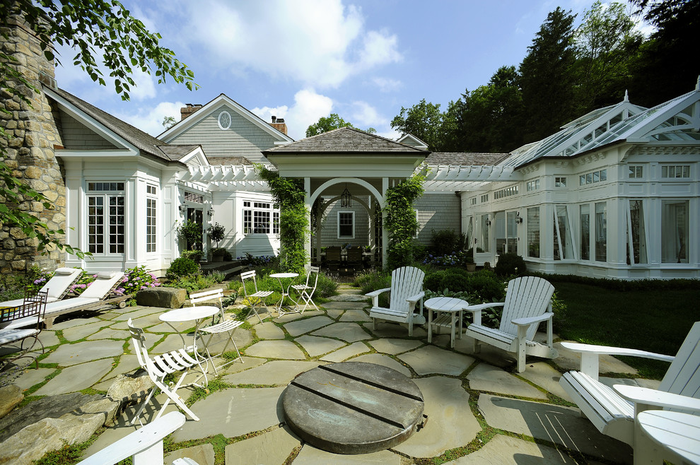 Design ideas for a large traditional backyard patio in New York with a fire feature, natural stone pavers and no cover.