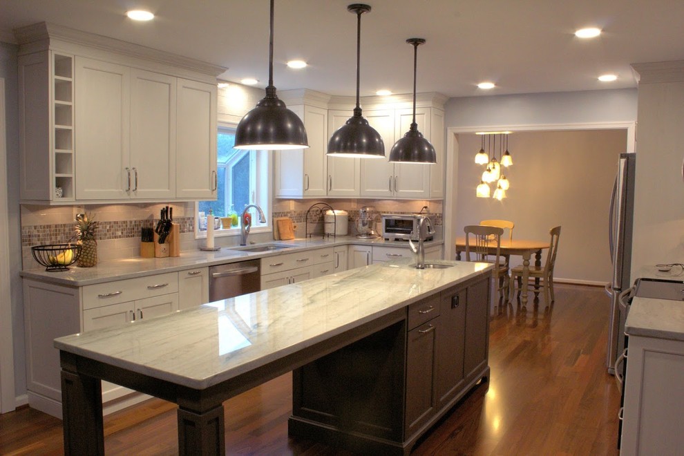 Large transitional galley medium tone wood floor and brown floor eat-in kitchen photo in Baltimore with a single-bowl sink, recessed-panel cabinets, white cabinets, quartzite countertops, gray backsplash, glass tile backsplash, stainless steel appliances, an island and multicolored countertops