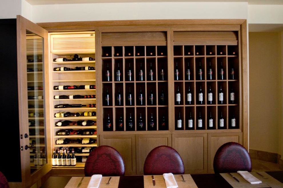 Design ideas for a mid-sized arts and crafts wine cellar in Other with medium hardwood floors, display racks and brown floor.