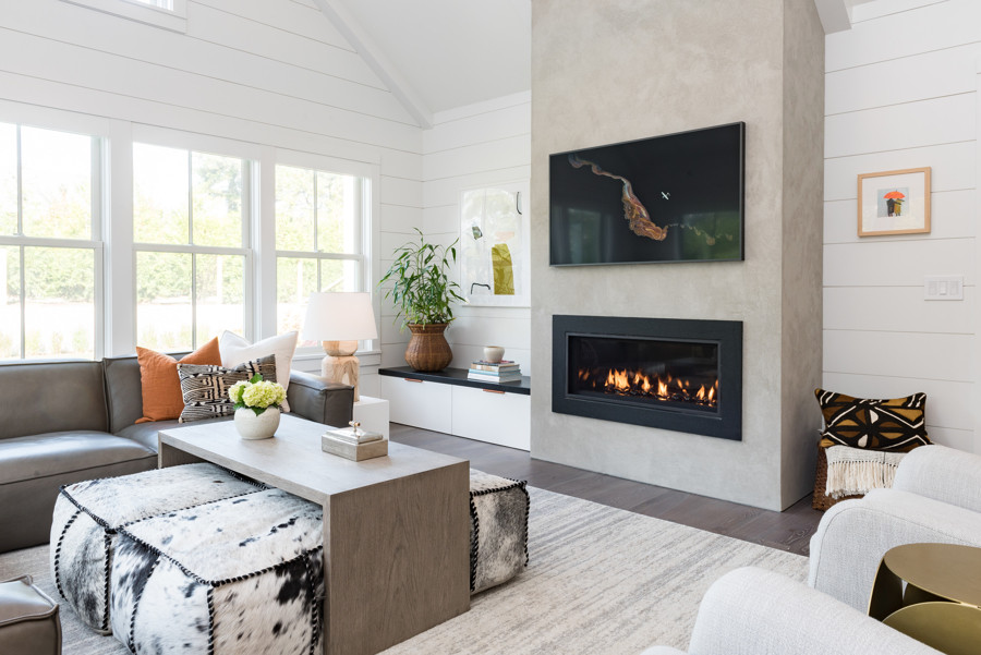 This is an example of a modern open concept living room in Boston with white walls, dark hardwood floors, a standard fireplace, a concrete fireplace surround, a wall-mounted tv and brown floor.