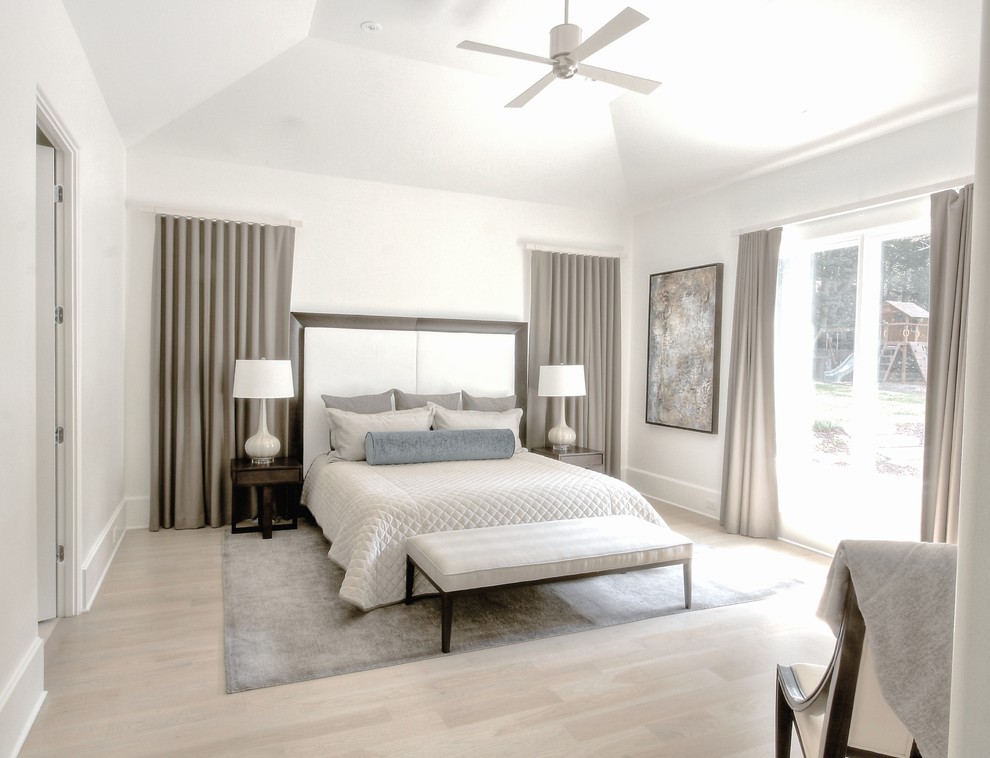 Design ideas for a transitional bedroom in Atlanta with white walls and light hardwood floors.