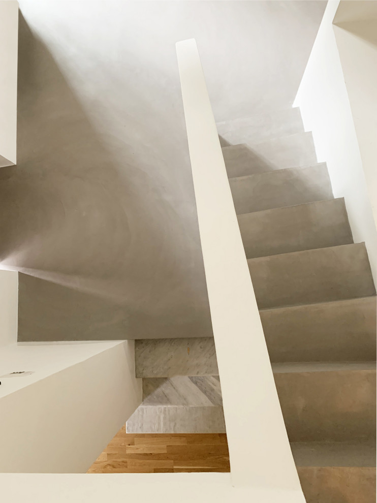 This is an example of a small classic concrete straight staircase in Rome with concrete risers.