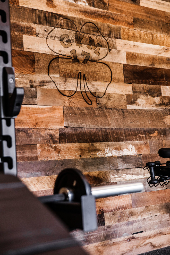 Photo of a mid-sized country home weight room in Phoenix with brown walls and black floor.