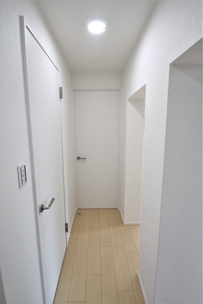 Foto di un ingresso o corridoio country con pareti bianche, pavimento in compensato, pavimento marrone, soffitto in carta da parati e carta da parati
