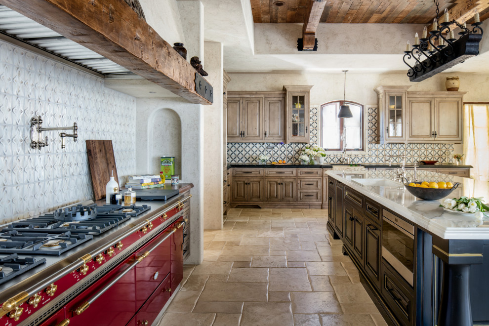 This is an example of an expansive mediterranean l-shaped eat-in kitchen in Los Angeles with a farmhouse sink, recessed-panel cabinets, light wood cabinets, marble benchtops, multi-coloured splashback, cement tile splashback, coloured appliances, travertine floors, with island, beige floor, white benchtop and wood.