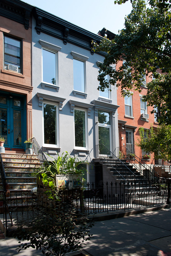 Photo of a large modern three-storey stucco grey house exterior in New York.