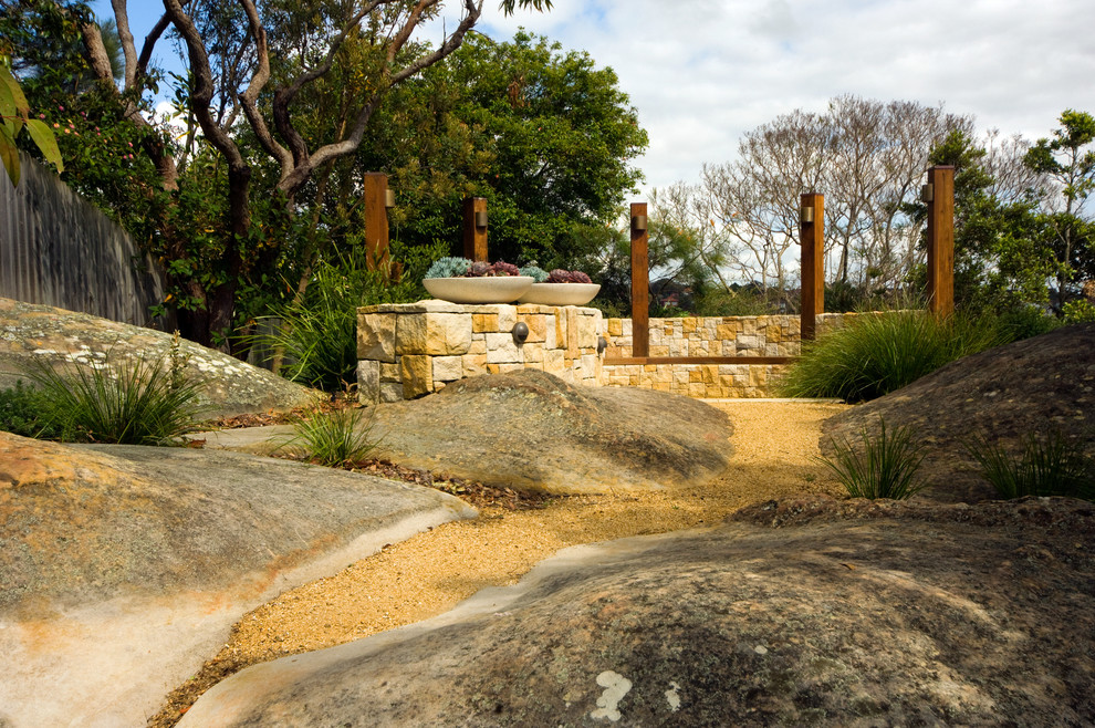 Design ideas for an australian native transitional backyard full sun garden for winter in Sydney with a fire feature and natural stone pavers.
