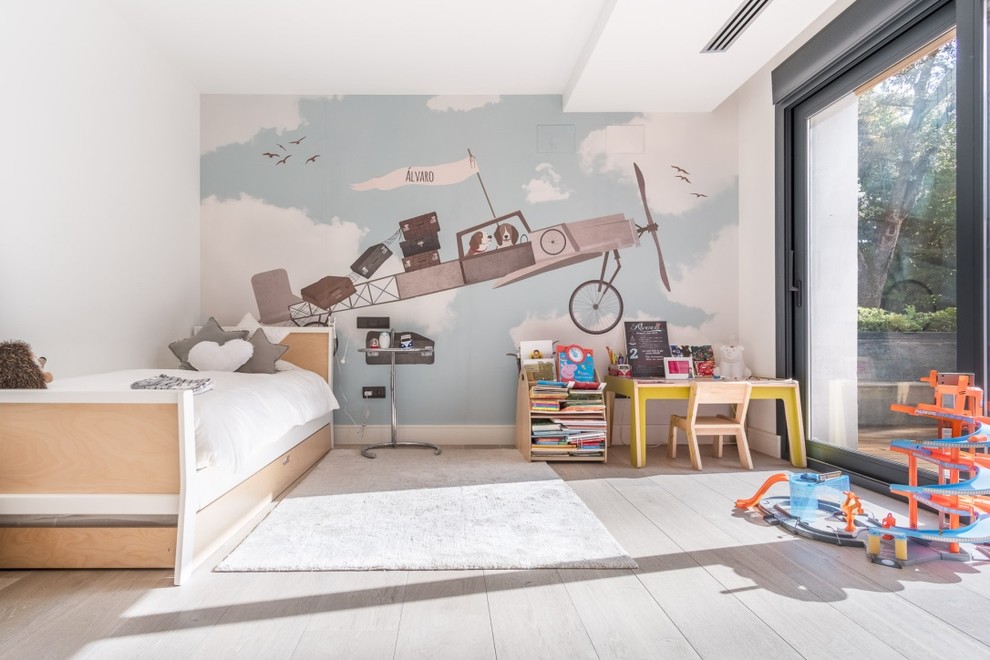 Photo of a scandinavian gender-neutral kids' bedroom for kids 4-10 years old in Madrid with multi-coloured walls, medium hardwood floors and brown floor.