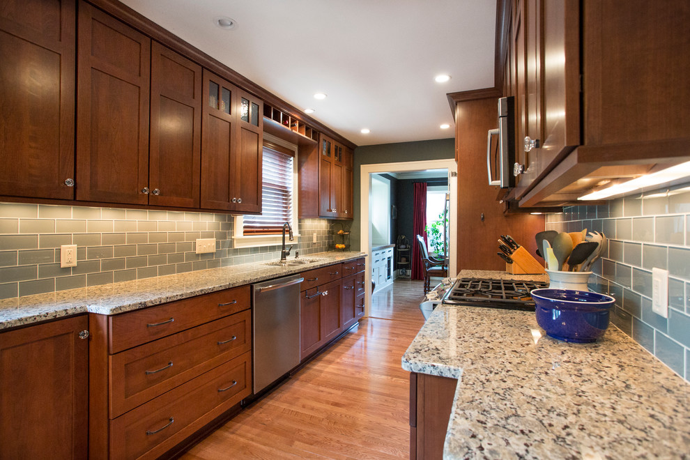 Mid-sized eclectic galley eat-in kitchen in Minneapolis with a double-bowl sink, shaker cabinets, dark wood cabinets, granite benchtops, blue splashback, subway tile splashback, stainless steel appliances, medium hardwood floors and no island.