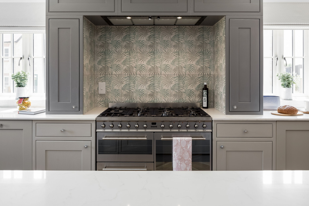 This is an example of an expansive transitional u-shaped open plan kitchen in Dorset with shaker cabinets, grey cabinets, quartzite benchtops and with island.