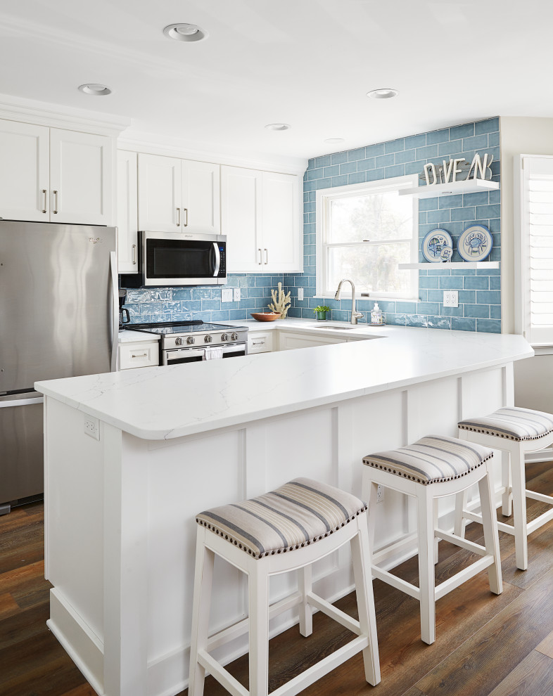 Small nautical galley kitchen/diner in Other with white cabinets, stainless steel appliances and a breakfast bar.