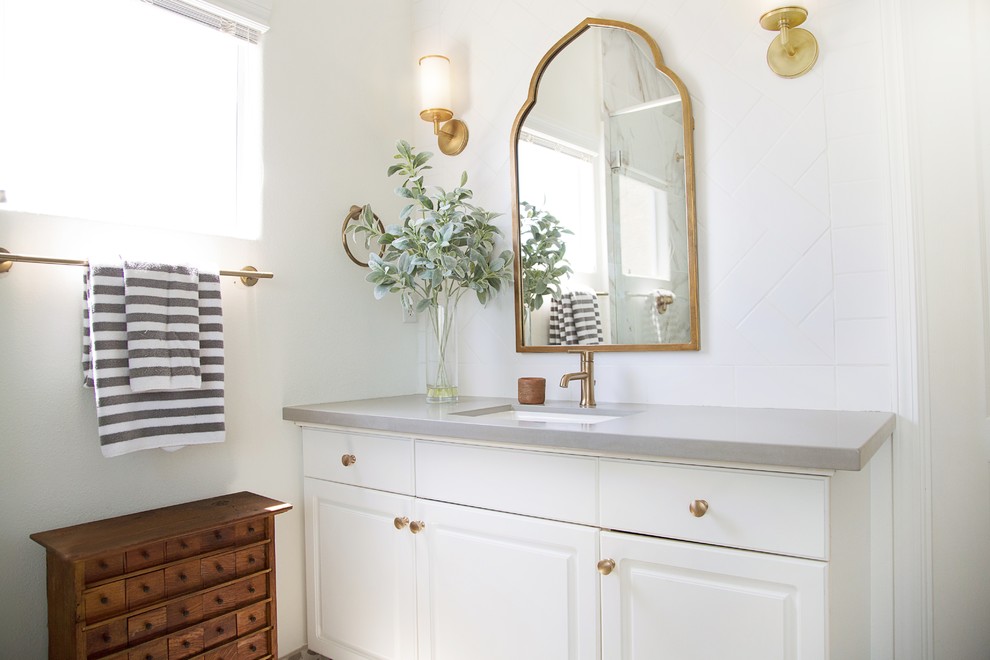Alcove shower - mid-sized transitional 3/4 white tile and porcelain tile alcove shower idea with raised-panel cabinets, white cabinets, a two-piece toilet, white walls, an undermount sink, solid surface countertops and a hinged shower door