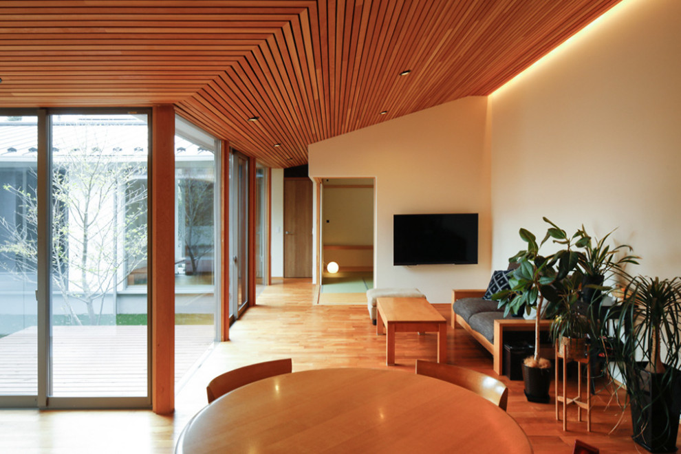 Идея дизайна: гостиная-столовая среднего размера с белыми стенами, темным паркетным полом, коричневым полом, деревянным потолком и обоями на стенах без камина