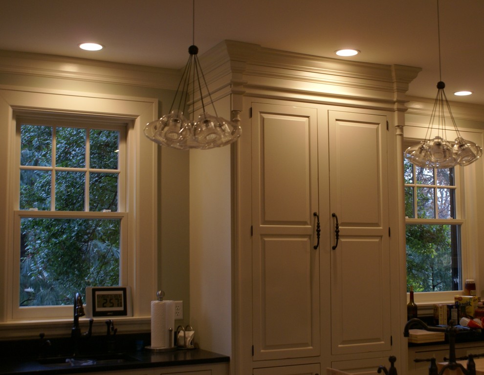 Inspiration for a rustic medium tone wood floor kitchen remodel in Chicago with a farmhouse sink, raised-panel cabinets, white cabinets, granite countertops, stainless steel appliances and an island