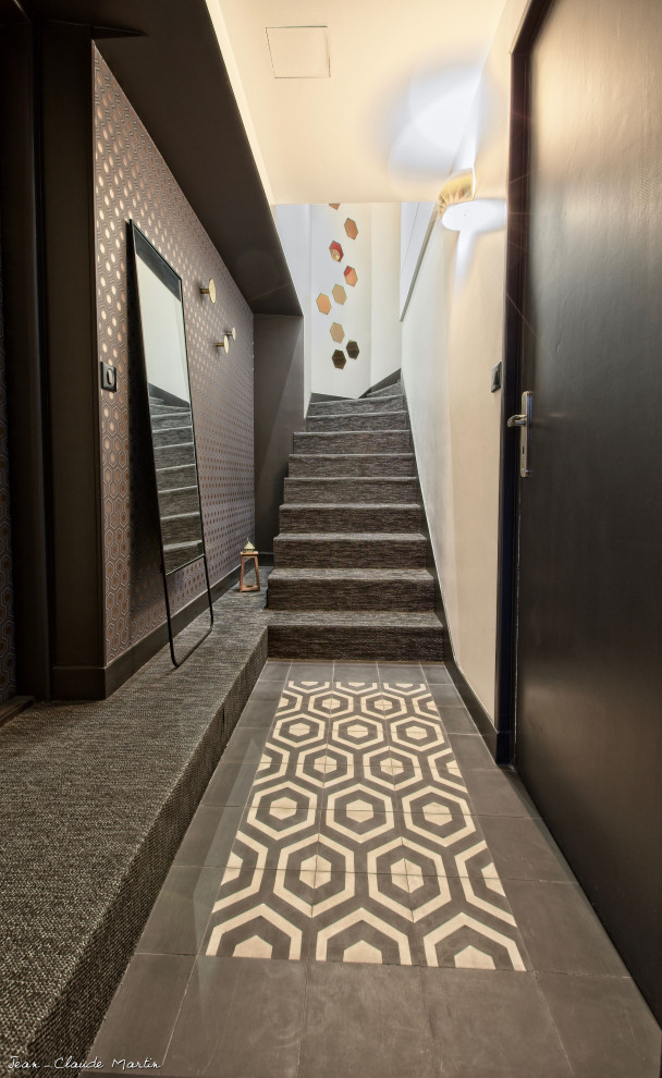 Midcentury foyer in Other with black walls, limestone floors, a single front door, black floor, recessed and wallpaper.