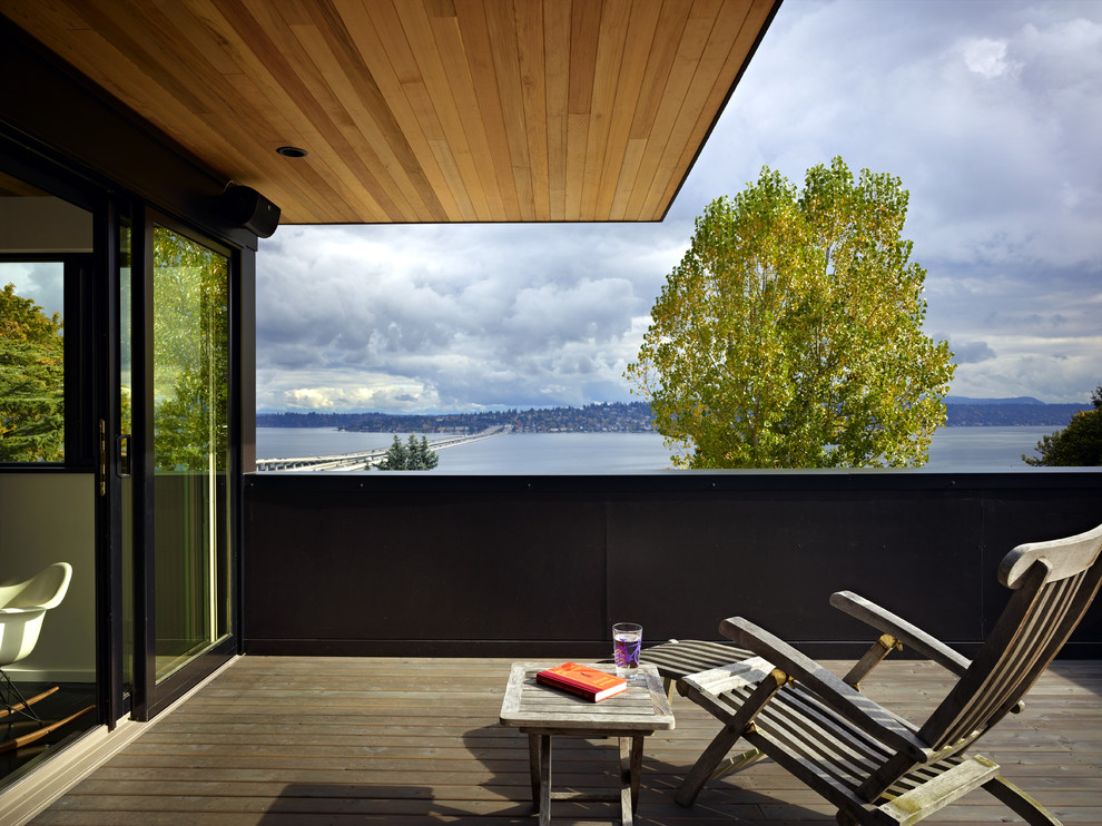 Design ideas for a mid-sized modern rooftop deck in Seattle with a roof extension.