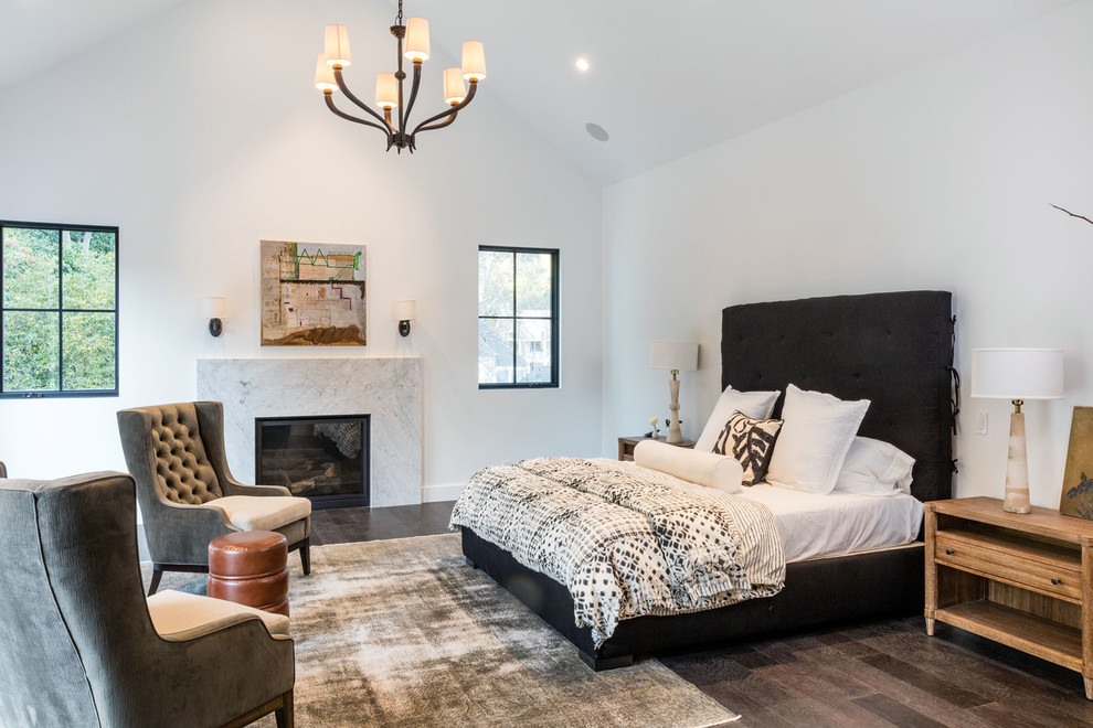 Photo of a contemporary master bedroom in Los Angeles with white walls, dark hardwood floors, a standard fireplace and a stone fireplace surround.