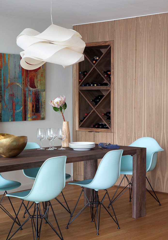 This is an example of a midcentury dining room in Austin with white walls and medium hardwood floors.