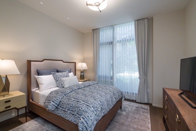 This is an example of a transitional guest bedroom in San Diego with beige walls, carpet and grey floor.