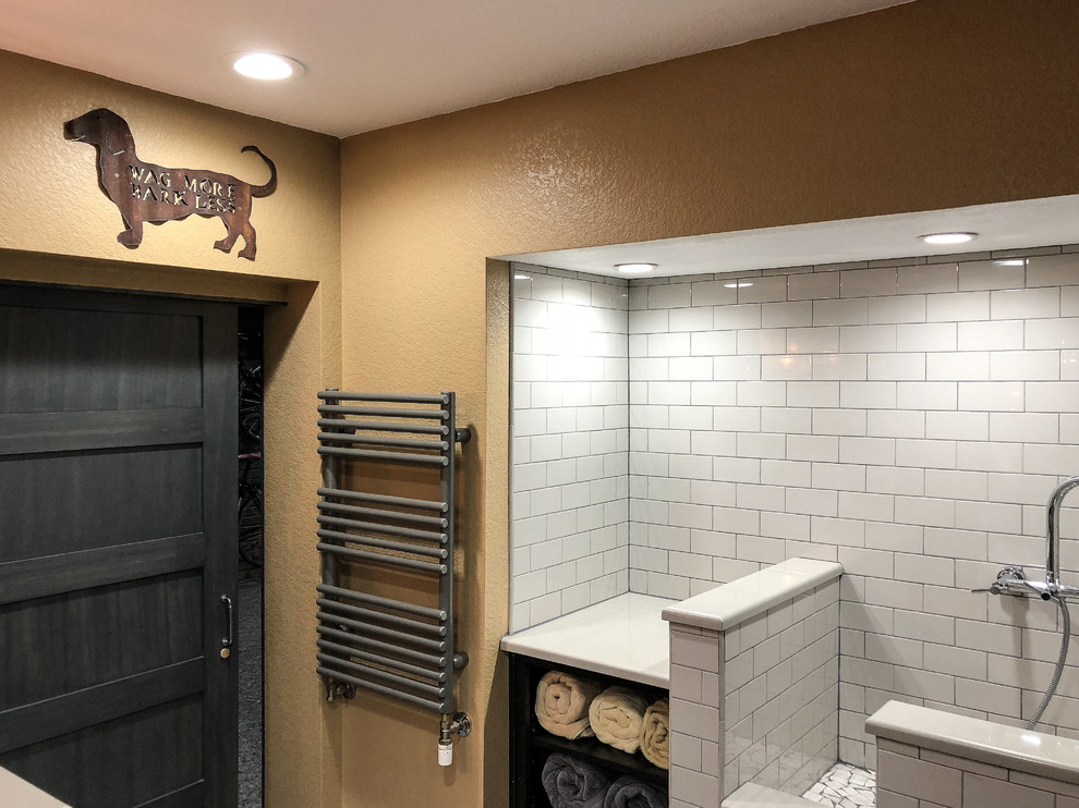 Photo of a mid-sized industrial 3/4 bathroom in Denver with flat-panel cabinets, dark wood cabinets, a curbless shower, a one-piece toilet, white tile, ceramic tile, yellow walls, concrete floors, an integrated sink, solid surface benchtops, grey floor, an open shower and beige benchtops.