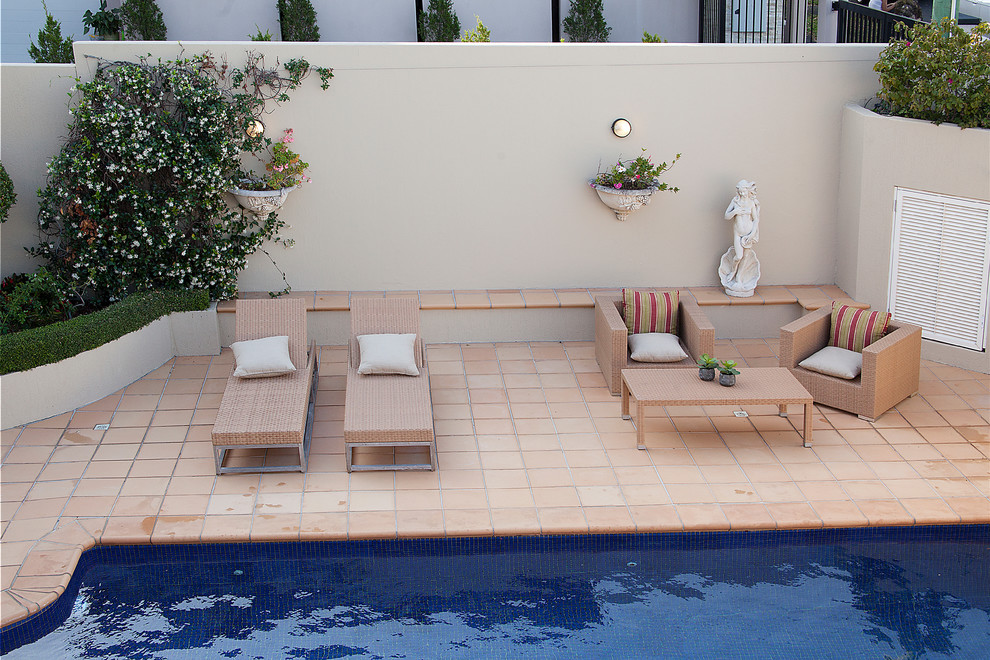 Photo of a large mediterranean front yard natural pool in Brisbane with natural stone pavers.