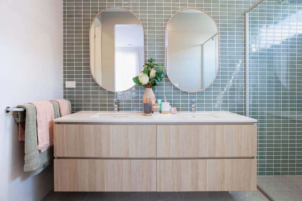 This is an example of a mid-sized contemporary master bathroom in Melbourne with light wood cabinets, green tile, ceramic tile, ceramic floors, an undermount sink, engineered quartz benchtops, white benchtops, flat-panel cabinets and grey floor.