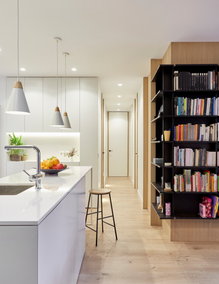 Diseño de biblioteca en casa abierta moderna grande con paredes blancas, suelo de madera en tonos medios, televisor colgado en la pared y suelo marrón