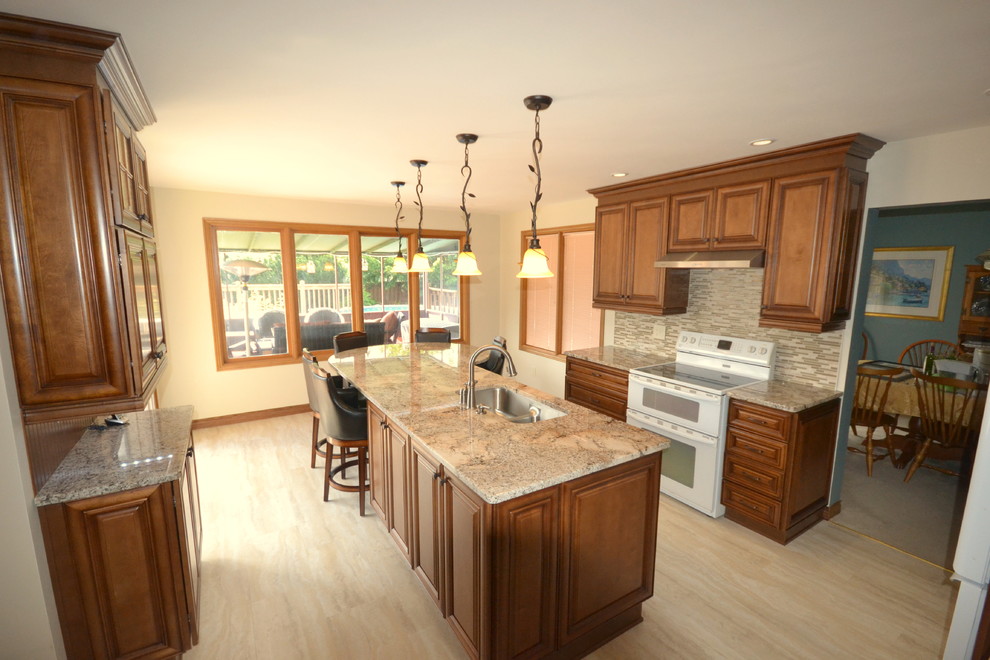 Inspiration for a mid-sized transitional u-shaped light wood floor and beige floor eat-in kitchen remodel in Toronto with a double-bowl sink, raised-panel cabinets, medium tone wood cabinets, granite countertops, multicolored backsplash, matchstick tile backsplash, stainless steel appliances and an island