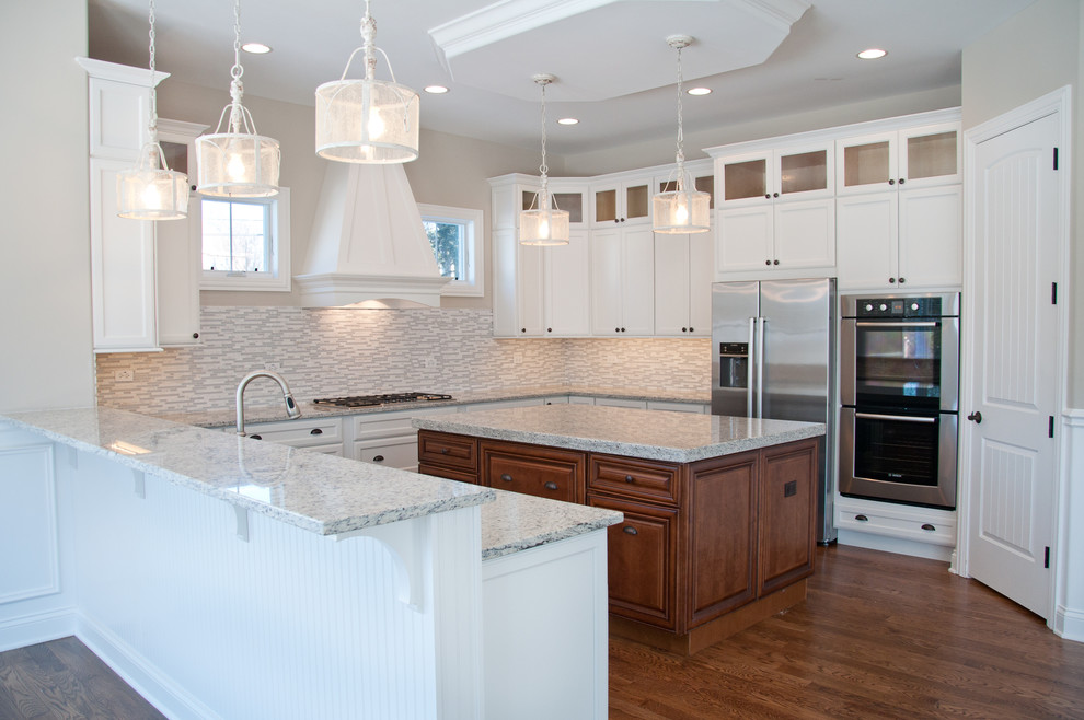 Example of a large transitional u-shaped medium tone wood floor kitchen pantry design in Cleveland with an undermount sink, white cabinets, marble countertops, gray backsplash, stone tile backsplash, stainless steel appliances and an island