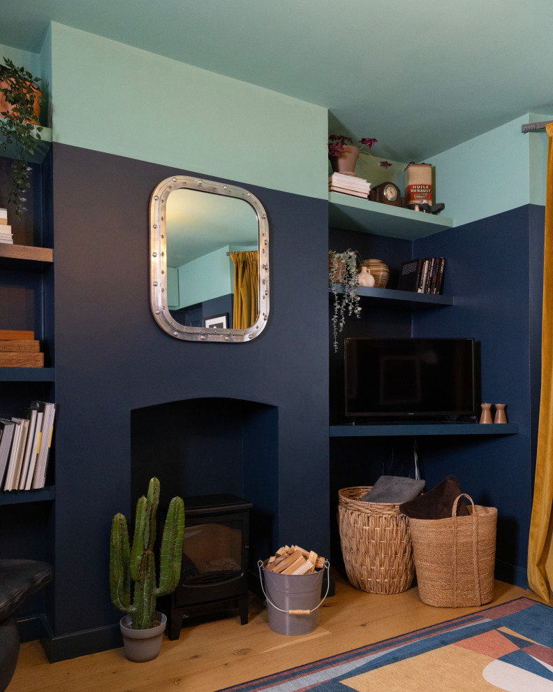 Idée de décoration pour un salon design de taille moyenne et fermé avec un mur bleu, un sol en bois brun, aucune cheminée, un téléviseur d'angle et un sol marron.
