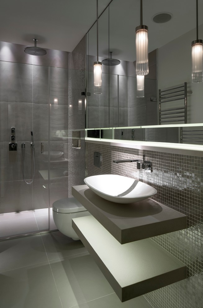 Inspiration for a contemporary 3/4 bathroom in London with a vessel sink, open cabinets, grey cabinets, a curbless shower, a wall-mount toilet, gray tile and grey walls.