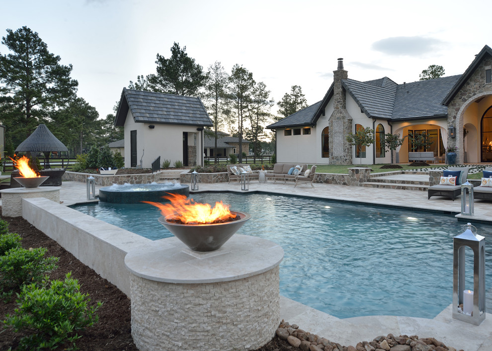 Photo of an expansive eclectic backyard custom-shaped natural pool in Houston with a hot tub and natural stone pavers.