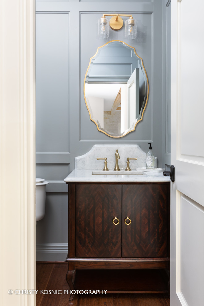Inspiration pour un WC et toilettes traditionnel en bois foncé de taille moyenne avec un mur gris, un lavabo intégré, un plan de toilette en marbre, un plan de toilette blanc, meuble-lavabo sur pied et du lambris.