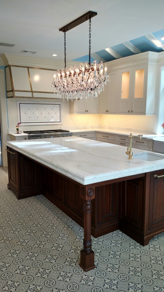 This is an example of a traditional u-shaped separate kitchen in New York with beaded inset cabinets, dark wood cabinets, marble benchtops, with island and white benchtop.