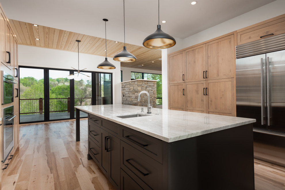 Mid-sized transitional u-shaped light wood floor eat-in kitchen photo with an undermount sink, shaker cabinets, light wood cabinets, quartzite countertops, stainless steel appliances and an island