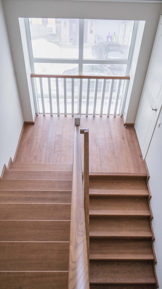 Photo of a medium sized modern wood u-shaped wood railing staircase in Moscow with wood risers, brick walls and under stair storage.