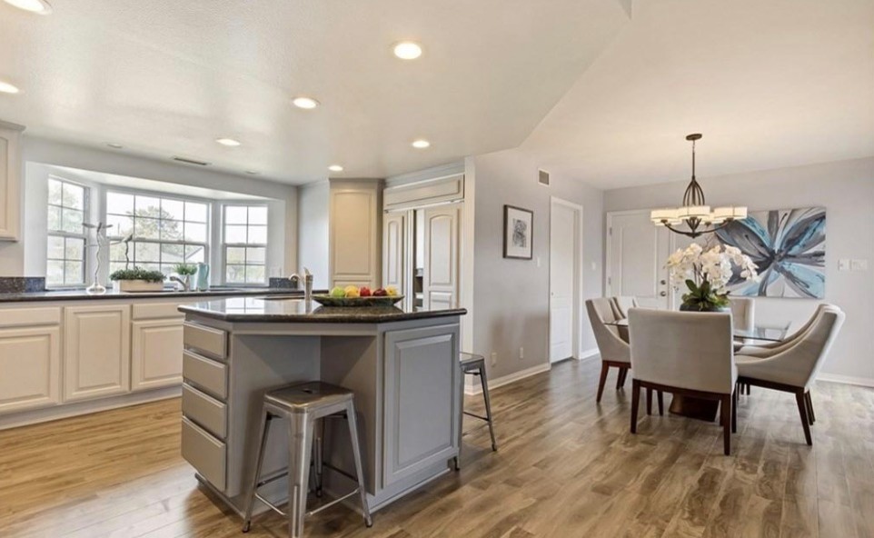 Inspiration for a mid-sized transitional u-shaped laminate floor and gray floor eat-in kitchen remodel in Orange County with an undermount sink, raised-panel cabinets, gray cabinets, granite countertops, black backsplash, marble backsplash, stainless steel appliances, an island and black countertops