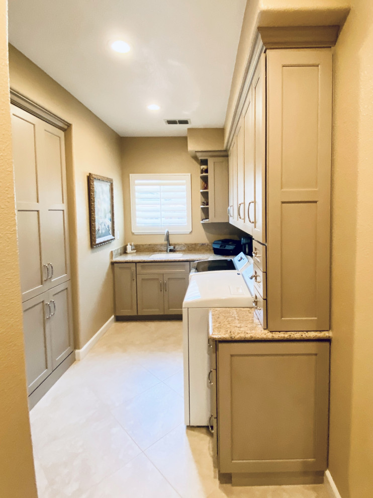 Design ideas for a mid-sized traditional u-shaped dedicated laundry room in San Francisco with an undermount sink, recessed-panel cabinets, beige cabinets, granite benchtops, beige splashback, stone slab splashback, beige walls, porcelain floors, a side-by-side washer and dryer, beige floor and beige benchtop.