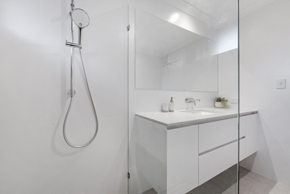 Photo of a small contemporary bathroom in Perth with white cabinets, an open shower, white tile, porcelain tile, white walls, porcelain floors, an undermount sink, engineered quartz benchtops, grey floor and an open shower.