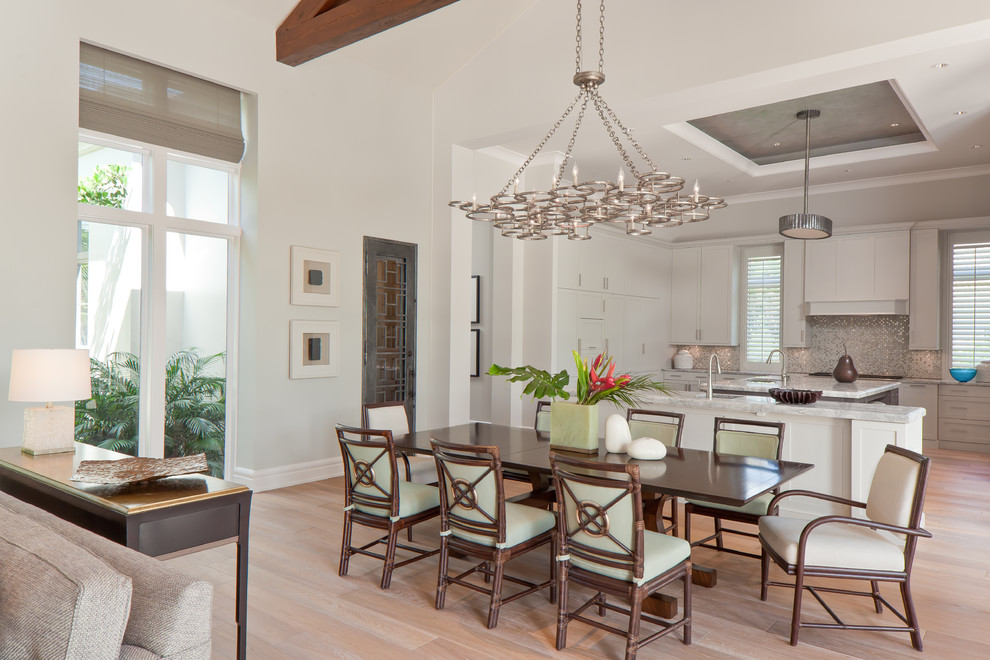 Design ideas for a transitional open plan dining in Miami with grey walls and light hardwood floors.
