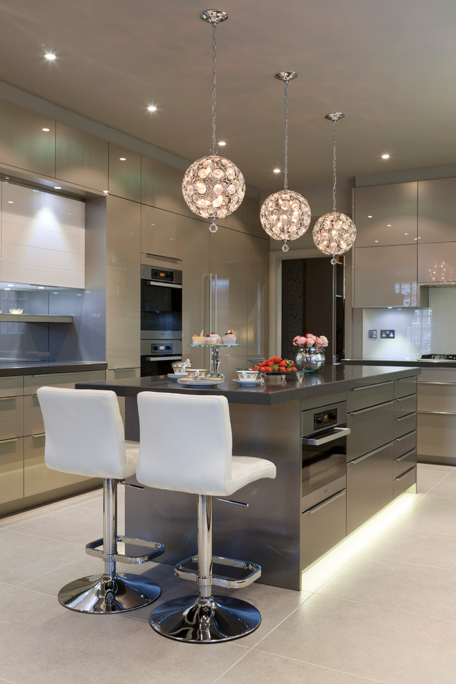 Photo of a large contemporary u-shaped kitchen in London with flat-panel cabinets, stainless steel appliances, ceramic floors, with island, grey cabinets and glass sheet splashback.