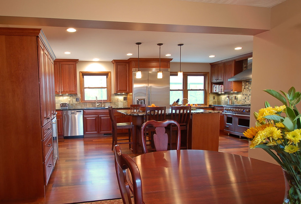 This is an example of a large traditional kitchen in Columbus with a double-bowl sink, granite benchtops, stainless steel appliances, medium hardwood floors and with island.