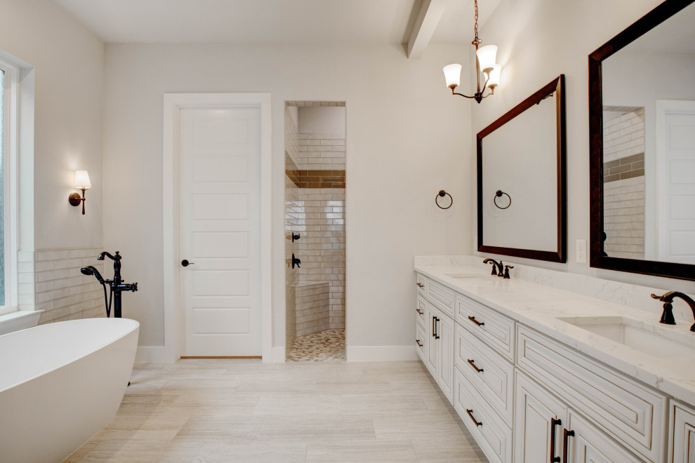 Foto på ett stort vintage vit en-suite badrum, med luckor med upphöjd panel, beige skåp, ett fristående badkar, en dusch i en alkov, ett undermonterad handfat, beiget golv och med dusch som är öppen