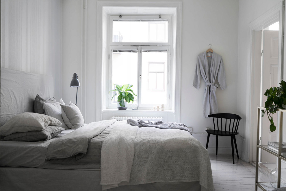 Scandinavian master bedroom in Stockholm with white walls.